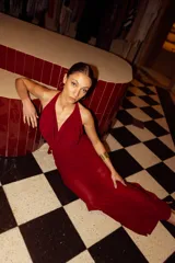 Vestido largo de microtul color bordó, con escote buche y cuello halter regulable. Presenta un diseño fluido con forro corto interno.