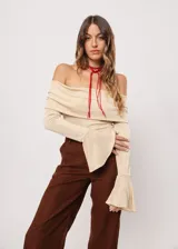 Blusa beige con hombros descubiertos, mangas largas acampanadas y confeccionada en tela stretch con lurex.