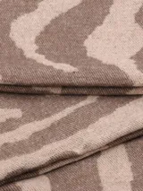 Bufanda rectangular con estampado animal print en tonos beige y marrón, con flecos en los extremos.