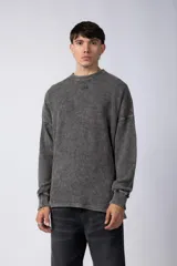 Buzo de corte oversize confeccionado en tela waffle de algodón con proceso de teñido acid wash, cuello redondo y mangas largas con puños acanalados.