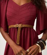 Vestido midi color bordó, con escote en V, mangas cortas evasé y falda en capas con recorte tipo María. La parte trasera tiene elástico para un mejor ajuste. Confeccionado en viscosa certificada y poliamida.