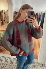 Sweater de punto con diseño de cuadros escoceses en escala XL, en tonos azul, verde y marrón. Presenta cuello redondo y puños con detalle de volados en color fucsia, con un corte oversize.