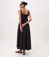 Vestido midi negro confeccionado en tricolina de algodón, con escote cuadrado, breteles anchos y corte con frunces laterales en la cintura. Presenta falda amplia y diseño de la marca Marfinno.