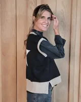 Chaleco de punto de algodón con diseño de estrella grande en la espalda. Presenta un corte holgado, cuello redondo y terminaciones en tejido acanalado en contraste de color.