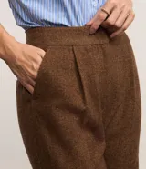 Pantalón recto de poliéster color marrón, con cintura alta de diseño sastre, pliegues delanteros y bolsillos laterales.