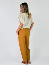 Pantalon de lino color mostaza con bolsillos laterales, tiro medio y corte recto.