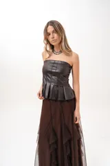 Top strapless de cuero sintético color marrón, con diseño de pliegues verticales tipo corsé y corte péplum en la parte inferior.