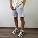 Short de algodón color beige melange, de diseño cómodo y holgado con bolsillos laterales y terminación descosida en las perneras.