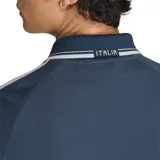 Campera deportiva Adidas Originals de la selección de Italia, color azul marino con cuello polo, cierre frontal completo, bolsillos laterales y las icónicas tres tiras blancas en las mangas. Presenta el logo del trébol de Adidas y el escudo de la selección italiana en el pecho.