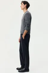 Pantalón sastrero de corte slim fit y color negro, con cierre frontal de botón, bolsillos laterales al bies y bolsillos posteriores ojalados. Cuenta con trabillas para cinturón y pretina elástica en la parte posterior.
