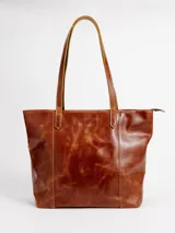 Cartera tote de cuero natural color beige, con doble asa larga para hombro y cierre superior con broche.