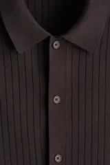 Camisa de punto acanalado color marrón, de corte regular, con cuello tipo polo y cierre frontal con botones.