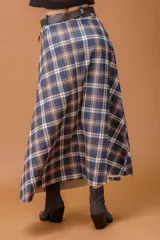 Falda midi de corte recto con estampado escocés en tonos chocolate, azul y beige. Presenta un diseño clásico con cintura alta y caída fluida.