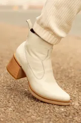Bota corta color crema de cuero con punta fina y taco cuadrado de madera.