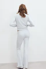 Pantalón de felpa gris melange, tiro alto con cintura elástica ancha y corte flare en las piernas.