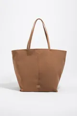 Bolso shopper grande de nylon marrón con estructura blanda, asas de hombro y detalles en piel. Cuenta con cierre de mosquetón, logo metálico de la marca en el frente y bolsillo interior.