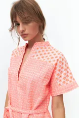 Vestido corto color coral con estampado de flores pequeñas, cuello mao y escote en V.