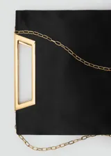 Bolso de mano tipo sobre con diseño cuadrado, confeccionado en poliéster negro. Cuenta con un asa metálica rígida en tono dorado y una cadena larga extraíble.