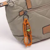 Bandolera verde militar con diseño acolchado y pespuntes diagonales, doble asa de mano en tono tostado y correa ajustable y desmontable. Cuenta con cierre superior y un bolsillo frontal con cremallera decorado con un llavero de cordón naranja con cuentas.