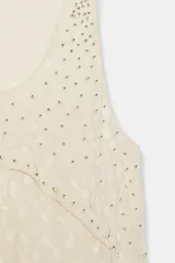 Vestido corto de viscosa color beige con diseño de jacquard, escote redondo y manga sisa. Presenta un diseño de paneles asimétricos con aplicaciones de abalorios decorativos en las costuras.