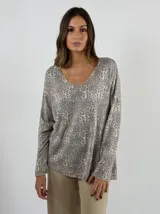 Sweater de punto color beige con estampado animal print en tonos grises, de corte holgado y mangas largas.