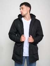 Parka larga gris con capucha, cierre frontal con cremallera y botones a presión, múltiples bolsillos y logo de Umbro en el pecho.