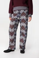 Pantalon de pierna recta con estampado tipo patchwork en tonos azul, bordó y blanco. Cuenta con cintura ajustable con elástico y cordón, dos bolsillos laterales redondeados y dos bolsillos traseros tipo plaqué.