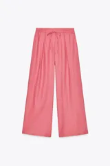 Pantalón de tiro alto color rosado, confeccionado en hilatura con lino, de pierna ancha y cintura elástica ajustable con cordones.