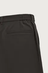 Pantalón regular fit color negro de corte recto, con cintura elástica en los laterales, trabillas, bolsillos frontales y cierre con botón y cremallera.