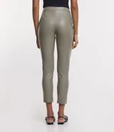 Pantalón tipo legging de mujer, color crema claro, confeccionado en poliuretano (PU) con un diseño liso. Presenta un cierre frontal con botones visibles en la cintura.