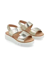 Sandalia dorada de estilo informal, con tiras ajustables con velcro y suela plataforma blanca.