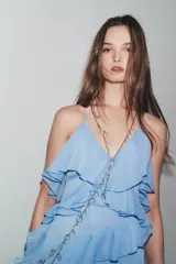 Vestido midi celeste con tirantes finos cruzados en la espalda y volantes en el mismo tejido.