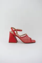 Sandalias rojas con capellada de cuero y rejilla, taco geométrico y pulsera al tobillo.