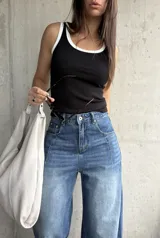 Musculosa de algodón color negro con ribetes blancos en el cuello y las sisas, de corte al cuerpo.