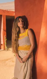 Top tejido a crochet color amarillo y beige, con cuello cuadrado y aberturas en el pecho y cintura.