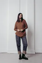 Sweater de punto con textura de ochos verticales, cuello redondo, mangas largas con puños acanalados y silueta relajada.