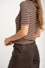 Sweater de punto acanalado color beige con hilos metalizados, de manga corta y escote redondo, corte ajustado al cuerpo.