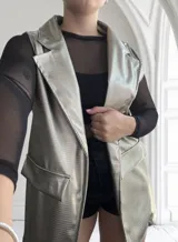 Chaleco largo dorado con textura simil piel de reptil, solapas y bolsillos delanteros.