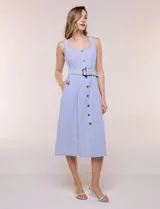 Vestido midi abotonado verde melange, con escote recto, tirantes anchos y falda de calce recto con vuelo sutil. Tiene abotonadura frontal completa con botones estilo carey, cinto textil con hebilla para ajustar la cintura y bolsillos laterales.