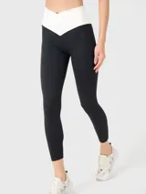 Calza deportiva negra con cintura alta en forma de "V" color crema.