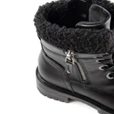 Borcegos de cuero sintético color negro, con caña media que presenta un detalle de tejido tipo corderito en el borde superior. Cuentan con cierre lateral, cordones frontales con ojalillos metálicos y suela track con taco de 4,5 cm.