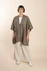 Ruana de lana fina sin teñir, con textura acanalada y terminaciones tejidas a crochet hechas a mano.