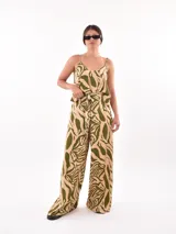 Pantalón palazzo estampado con motivos de hojas en tonos beige y verde.