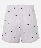 Short de pijama de poliéster color rosado con estampado de pequeños corazones oscuros, cintura elastizada con botones frontales decorativos y terminación de encaje en los bajos.