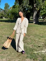Camisa larga de brocato con textura en punto smock, escote en V con lazos ajustables y mangas abullonadas, diseñada con terminaciones de flecos en los bordes.