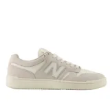 Championes New Balance Numeric 480 de estilo retro, confeccionados en una combinación de gamuza y cuero en tonos crema y blanco. Presentan el logo N en el lateral, suela de goma plana y perforaciones en la puntera para mayor ventilación.