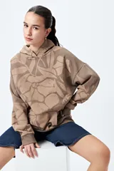 Canguro con capucha y bolsillo canguro frontal, de corte relajado. Presenta un estampado floral en tonos café y beige.