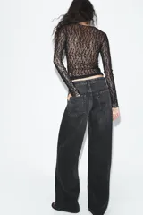 Jeans de tiro medio y corte wide leg en color marrón oscuro, con diseño de cinco bolsillos y cierre frontal con cremallera y botón metálico.
