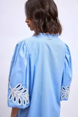 Vestido blanco de lino con escote en V, mangas cortas abullonadas y bordados florales en beige en mangas y ruedo.