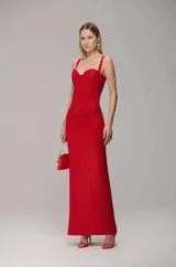 Vestido largo rojo con textura efecto piel de cocodrilo, diseño tipo corset con escote corazón y breteles anchos. Presenta una silueta ajustada en el torso y falda recta con caída fluida.